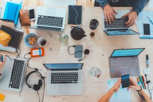 table de reunion avec des ordinateurs, des casques, des disque dur