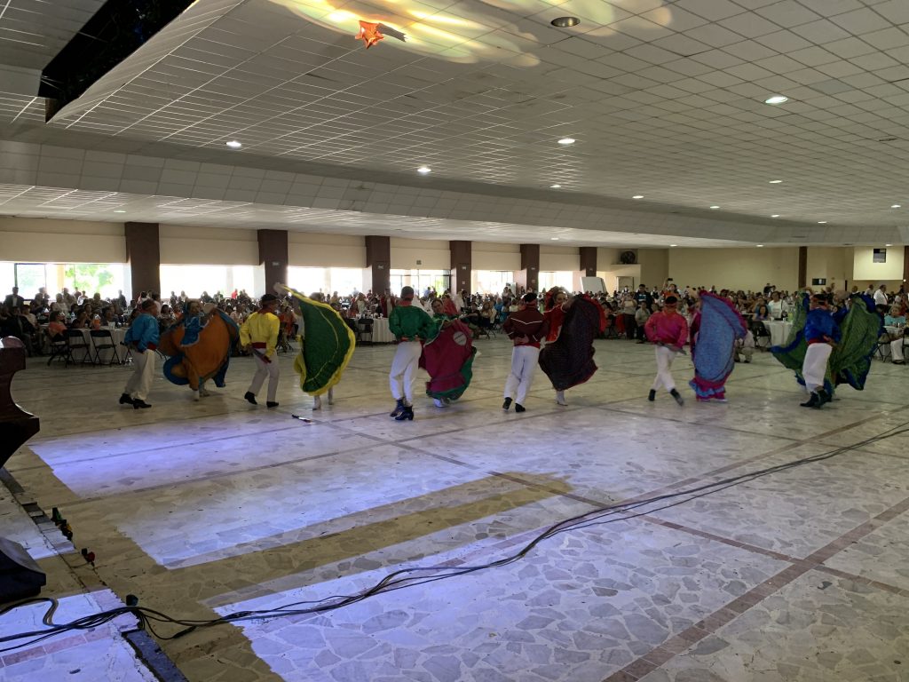 salle de personne avec des danseurs traditionnels mexicains au milieu