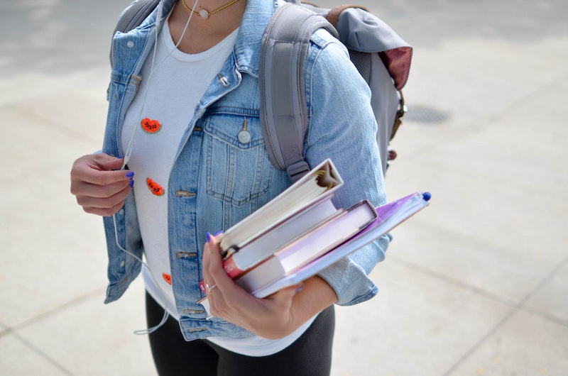 1 étudiantes qui portent des cahiers et livres