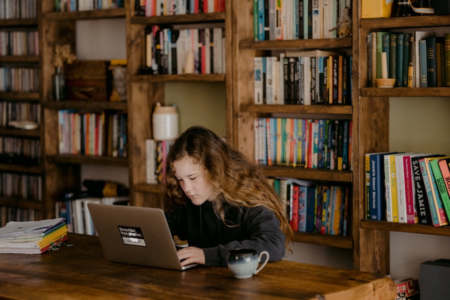 adolescente qui étudie dans une bibliothèque