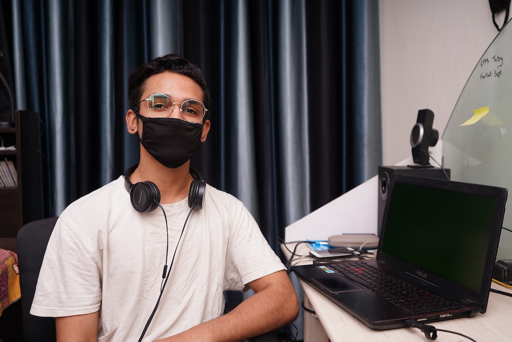 etudiant qui pose a cote d'un ordinateur