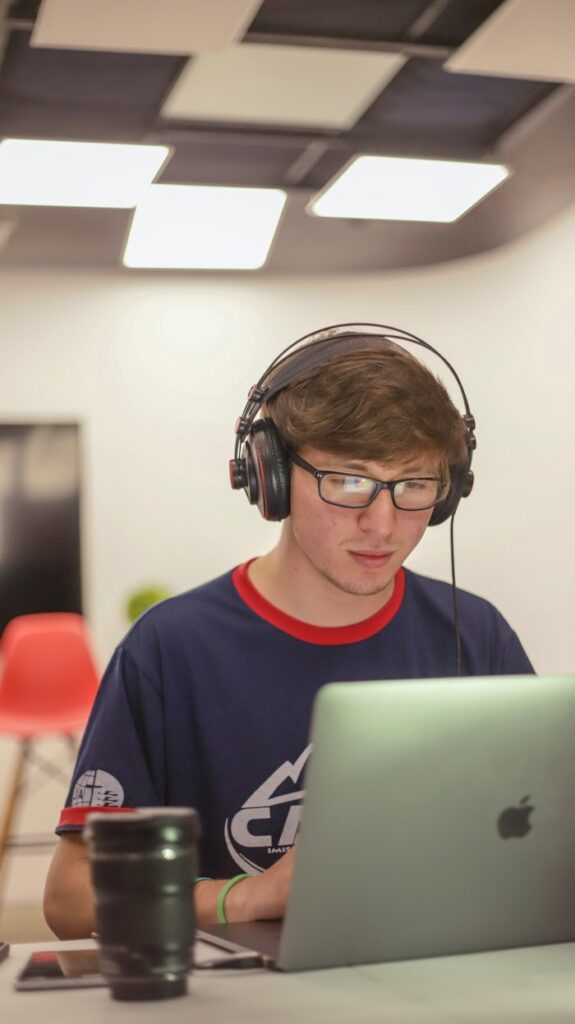 etudiant avec un casque de musique devant son ordinateur