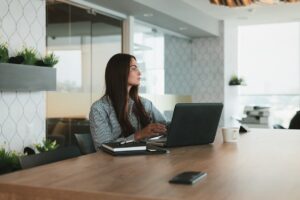 Fille qui réfléchit sur un bureau avec son ordinateur