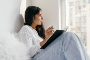 Fille qui réfléchit avec un cahier dans les mains