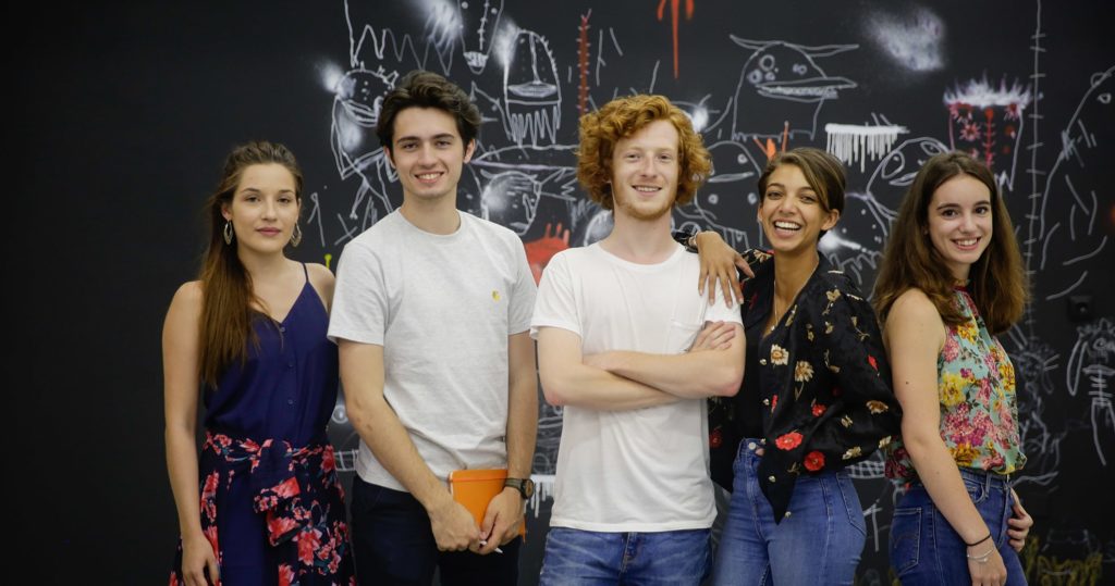 5 étudiants qui posent devant une fresque à l'ICART Paris